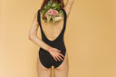 a-back-view-of-a-woman-in-black-bodysuit-holding-flowers